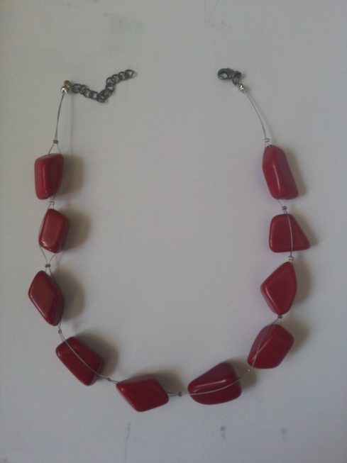 The chunky red necklace I remade for Miss Busty La Belle. It's red semi-precious stone of some variety and tiger tail. 